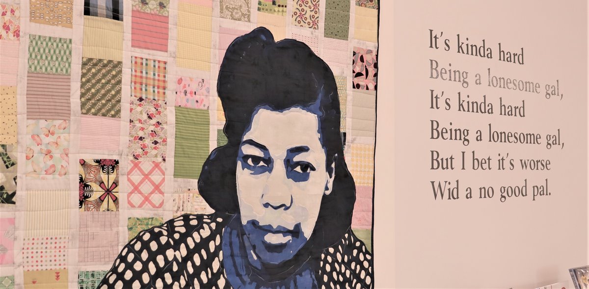 article thumb - A close up of a quilted portrait made by Dr Chinelo L. Njaka, showing Una Marson, on display in the Una Marson Library, with a quotation from one of her poems featured on the wall next to it.